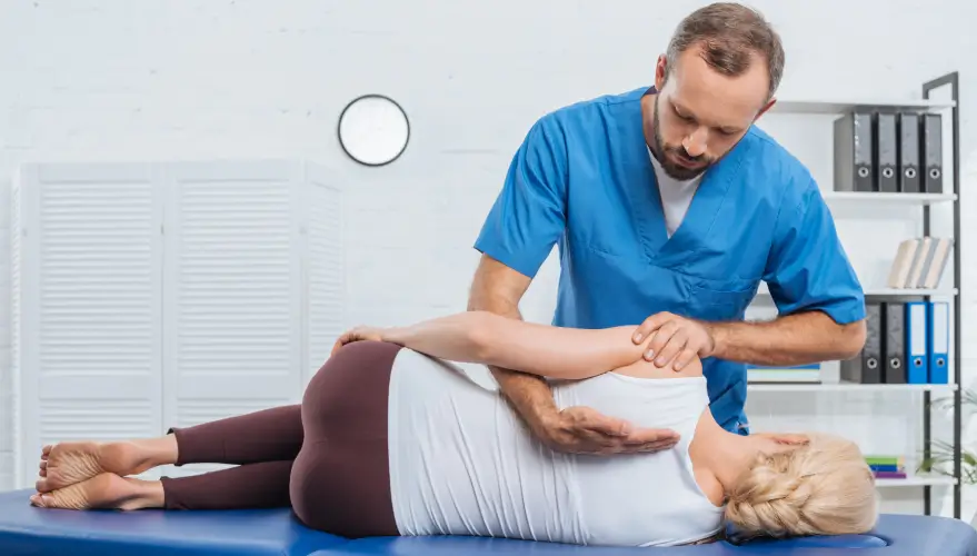 A patient receives a chiropractic and massage on their back from an adjustment chiropractor
